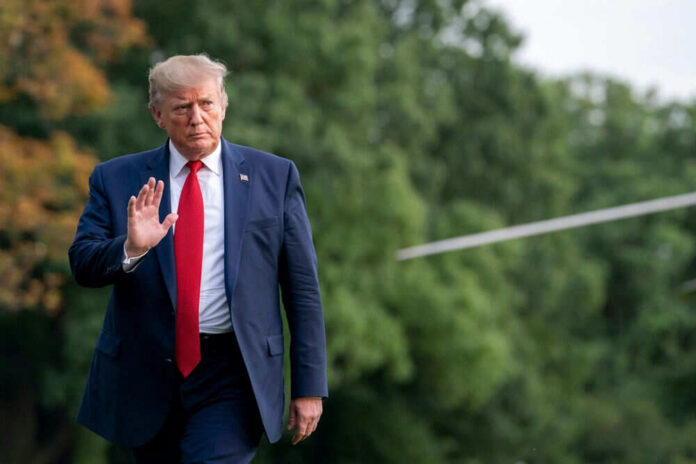 Person in suit walking outdoors waving hand