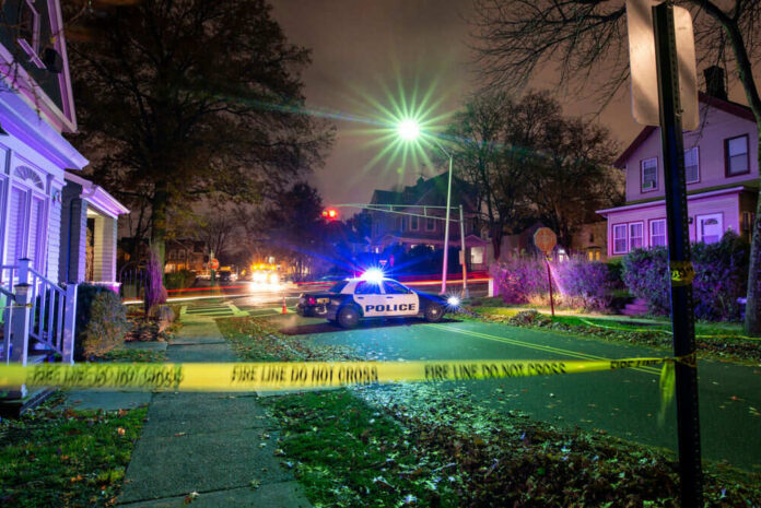Police car at night with caution tape nearby