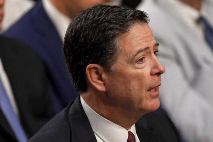 A man in formal attire speaking during a government hearing