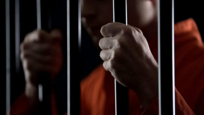 Person holding metal bars in dark setting