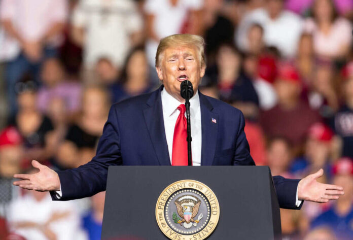 Man speaking at podium with seal in crowded venue