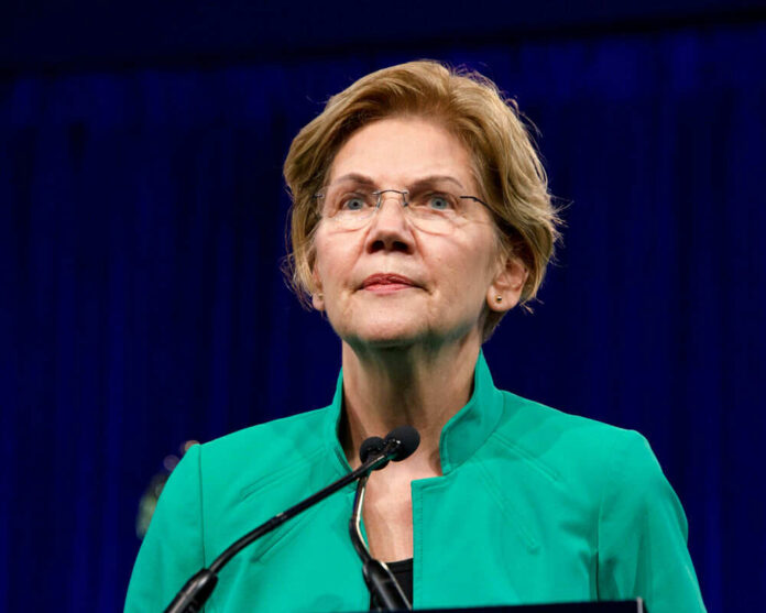 Person speaking at podium wearing green jacket