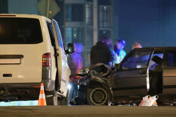 Two cars crashed at night with people nearby