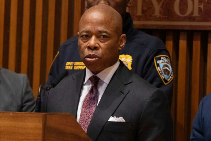 Man speaking at podium police officer in background