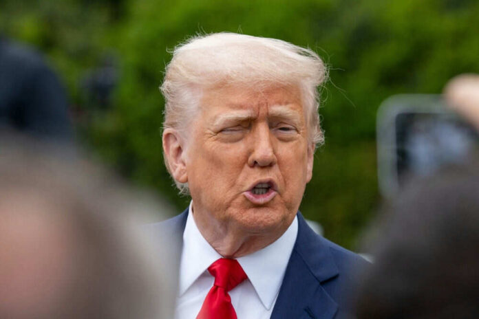 Person in suit talking outdoors with trees background