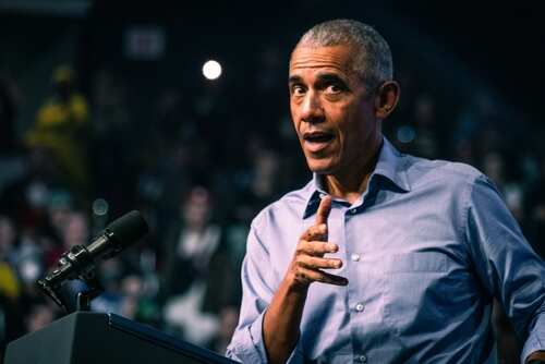 A speaker gesturing while addressing an audience