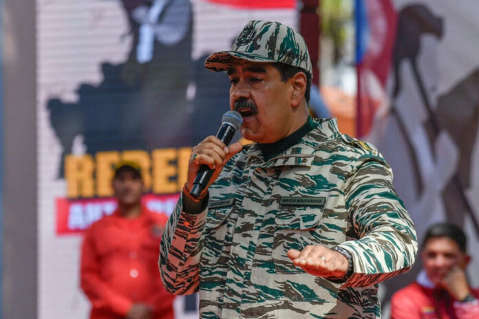 Man in camouflage uniform speaking at event outdoors