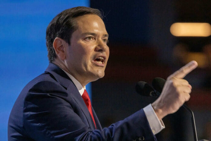 Man in suit speaking at a podium indoors