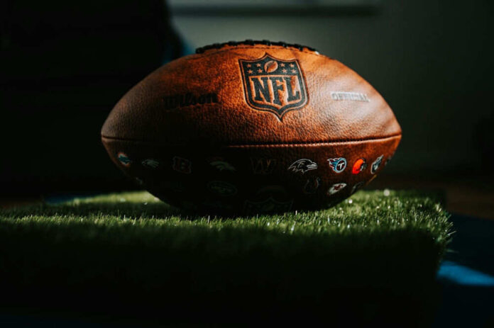 NFL football resting on artificial grass indoors
