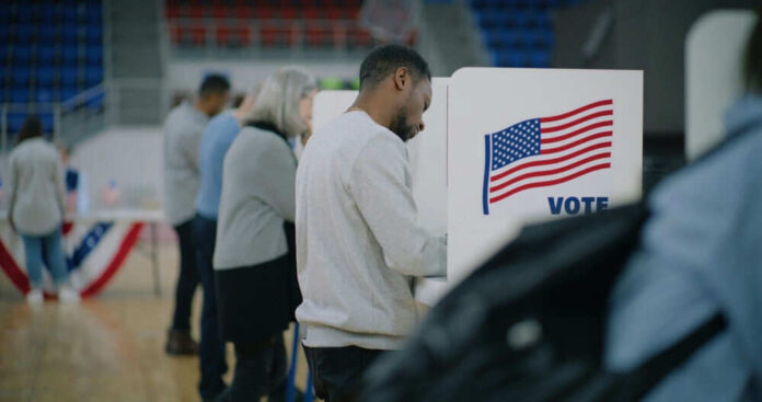 People voting at polling station with voting booths