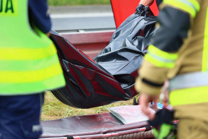 Emergency responders with black bag near roadside