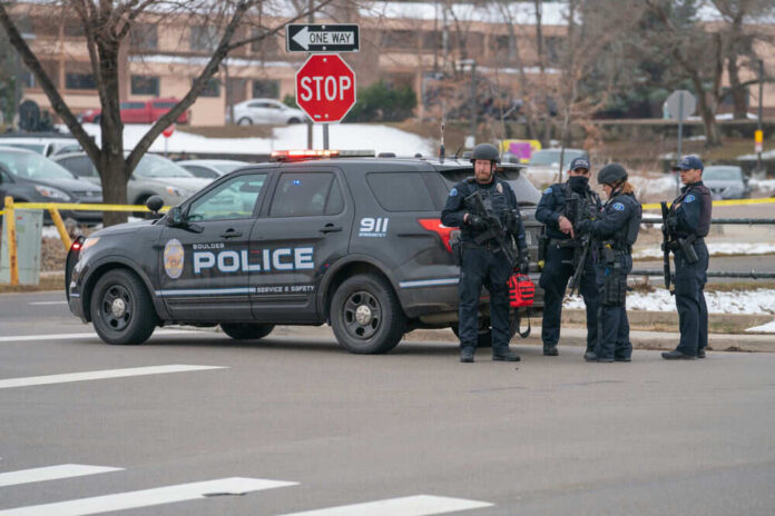 Police officers gathered around a patrol vehicle