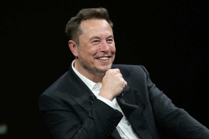Man in a black suit smiling broadly