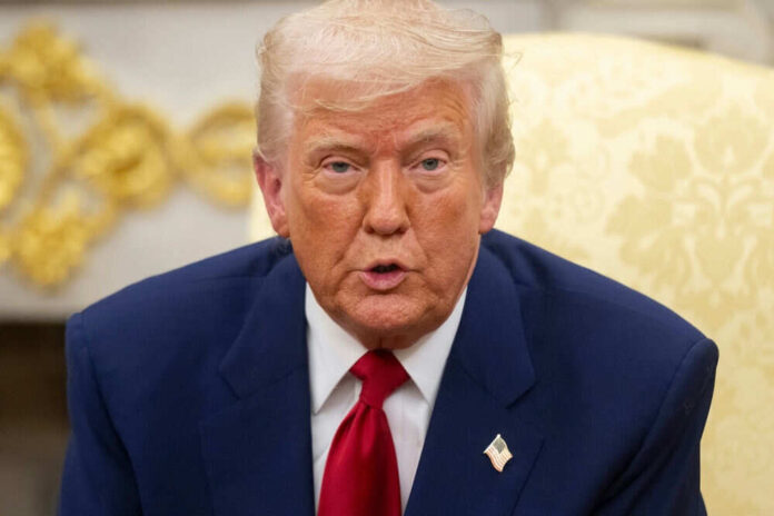 Man in suit with red tie speaking indoors
