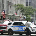 Police vehicles on busy city street with people
