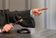 Judge pointing and holding gavel in hand