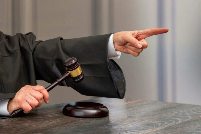 Judge pointing and holding gavel in hand